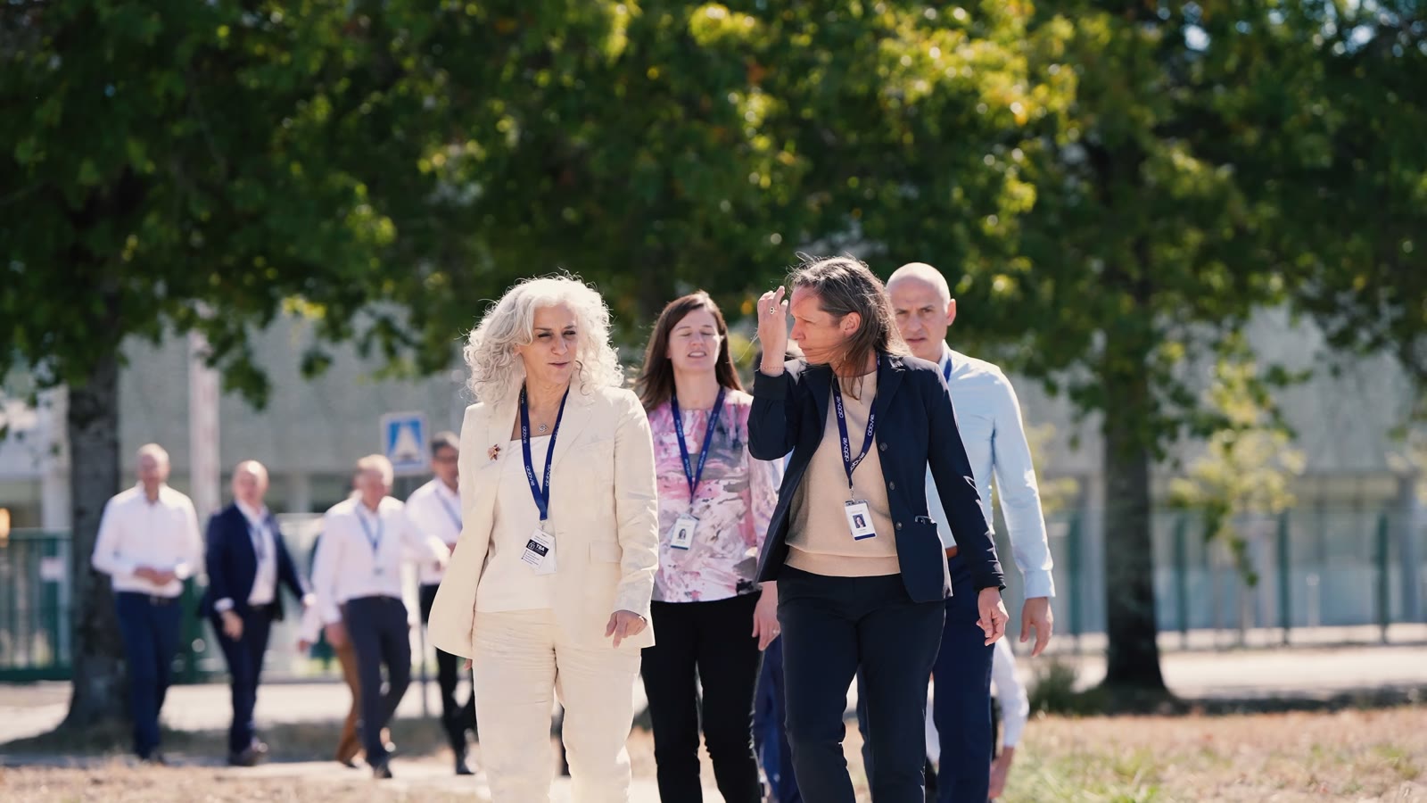 Groupe de collaborateurs AbbVie marchant dans le parc du site de Martillac, en contre-jour