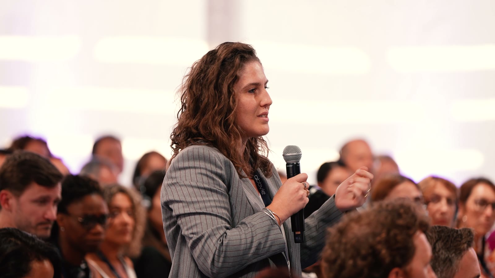 Une participante pose une question au micro depuis la salle pendant la plénière AbbVie