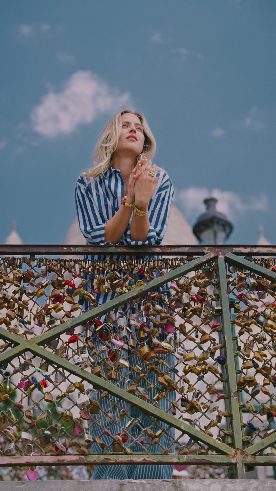 Camille en chemise rayée bleue devant le Sacré-Cœur, jonc doré au poignet