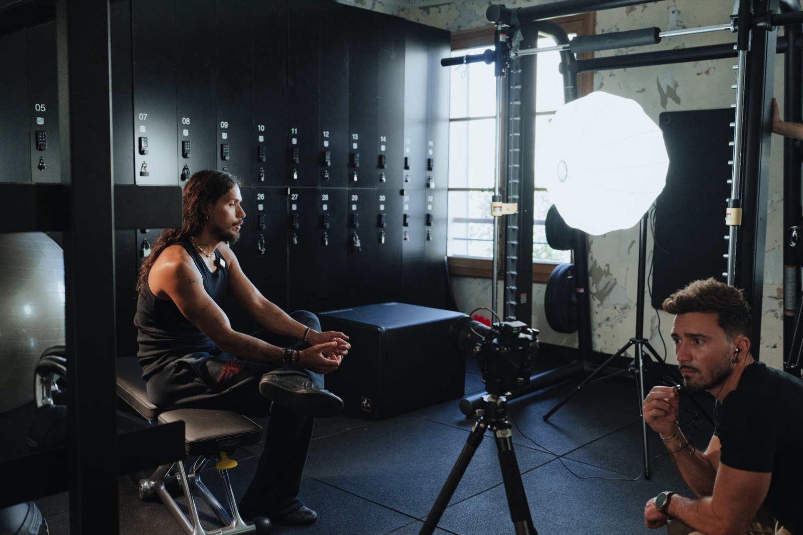 Plateau d'interview de Harry Nuriev : caméra sur pied, softbox et casiers noirs Technogym dans l'appartement rue des Beaux-Arts